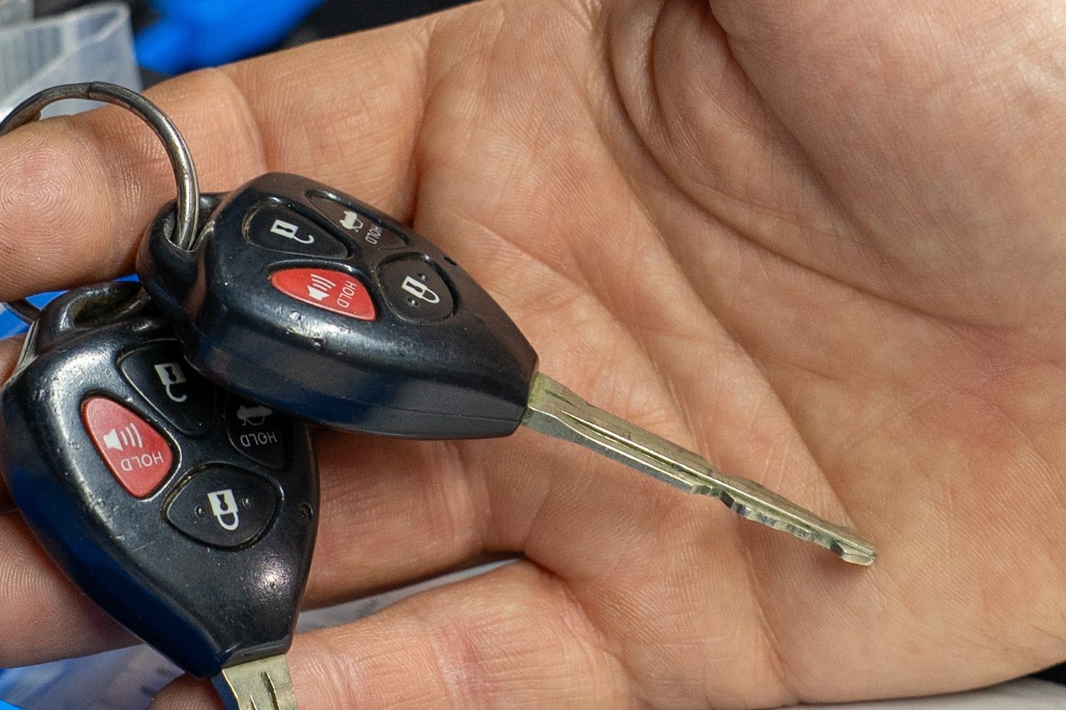 Two freshly cut car keys resting in an open palm.
