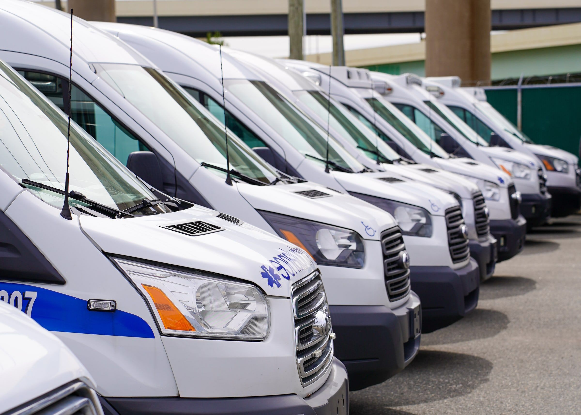A row of white fleet vans parked side by side.